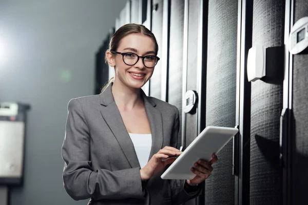 Enfoque selectivo de la alegre empresaria sosteniendo tableta digital en la sala de servidores — Stock Photo