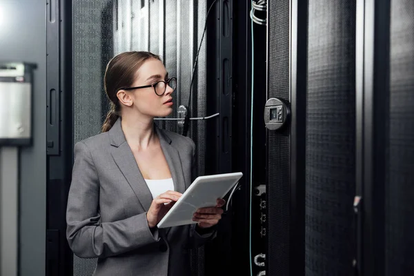 Selektiver Fokus der Geschäftsfrau in Brille mit digitalem Tablet in der Nähe von Serverschränken — Stockfoto