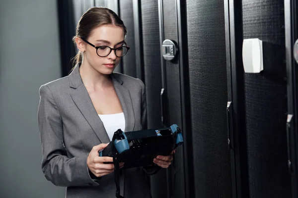 Selective focus of businesswoman holding reflectometer in data center — Stock Photo