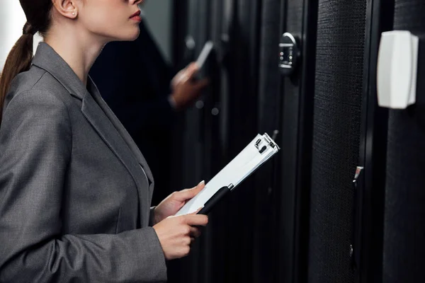 Abgeschnittene Ansicht einer Geschäftsfrau mit Klemmbrett in der Nähe eines Geschäftsmannes im Datengalopp — Stockfoto