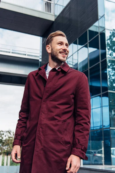 Cheerful bearded man smiling near building outside — Stock Photo