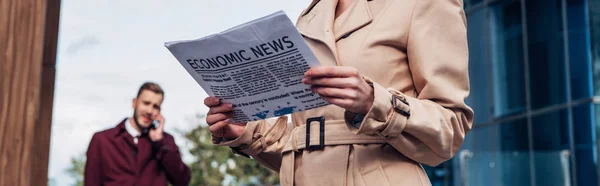 Plano panorámico de la mujer sosteniendo periódico cerca de hombre - foto de stock