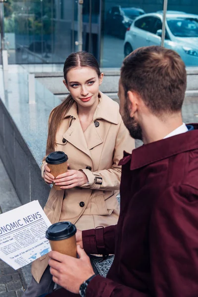 Foyer sélectif de femme attrayante regardant l'homme avec le journal et le café pour aller — Photo de stock