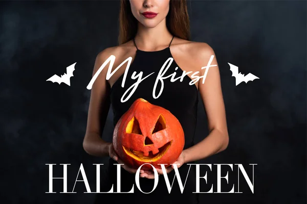 Vista ritagliata della donna che tiene zucca di Halloween con la mia prima scritta di Halloween — Foto stock