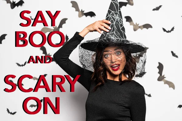 Verrückte Frau mit Hexenhut blickt zu Halloween in die Kamera und gruselt auf rotem Schriftzug — Stockfoto