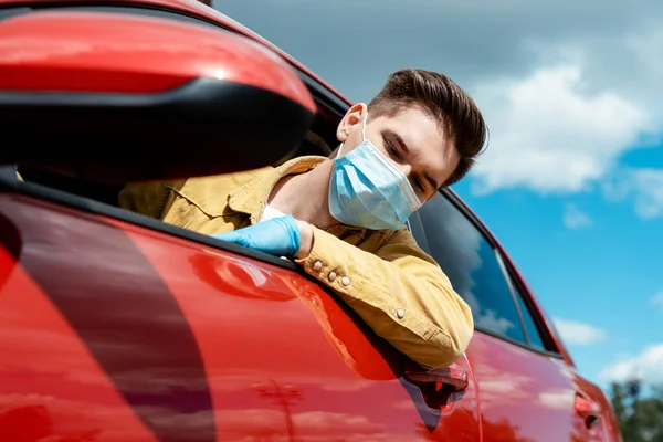 Man in medical mask and protective gloves driving taxi during covid-19 pandemic — Stock Photo