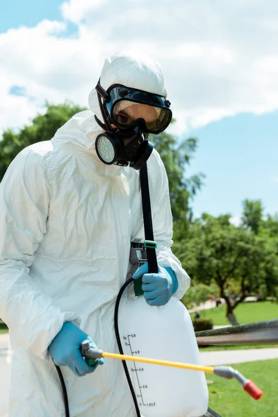 Spezialist in Schutzanzügen und Atemschutzmasken zur Desinfektion des Parks während der Coronavirus-Pandemie — Stockfoto