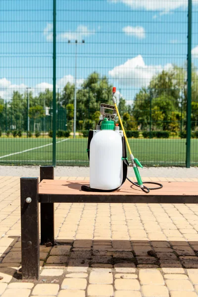 Borsa spray con disinfettante in piedi su panca all'aperto durante la pandemia di coronavirus — Foto stock