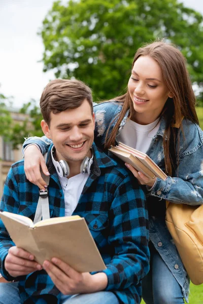 Foco seletivo de estudantes felizes e jovens livro de leitura — Fotografia de Stock