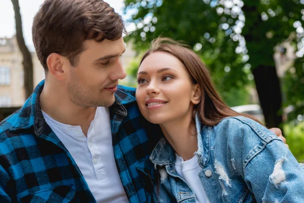 Schöne Mädchen und schöner Freund lächelnd, während sie einander anschauen — Stockfoto