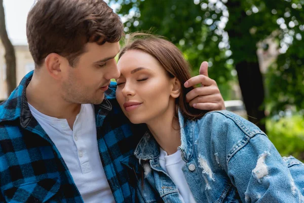 Schöner Mann, der Haare einer attraktiven Freundin mit geschlossenen Augen berührt — Stockfoto