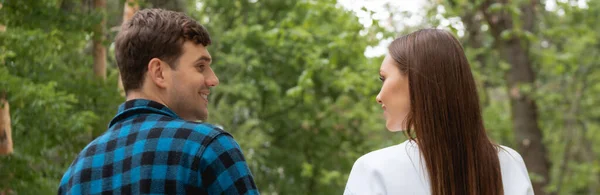 Imagem horizontal de namorado bonito e namorada bonita olhando um para o outro no parque — Fotografia de Stock