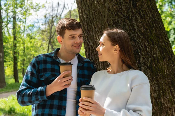 Glückliche Schüler, die Pappbecher in der Hand halten und einander anschauen — Stockfoto