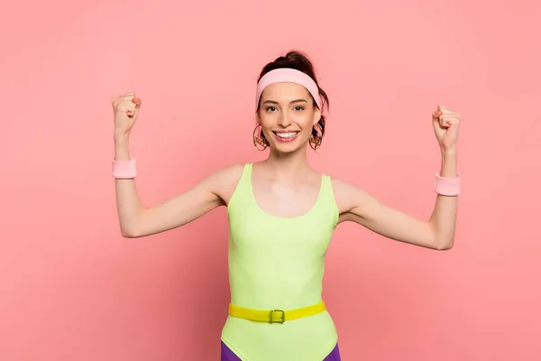 Desportista alegre com punhos apertados olhando para a câmera em rosa — Fotografia de Stock