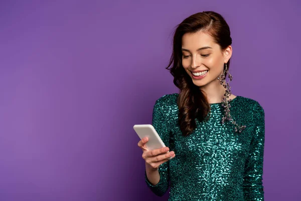 Щаслива молода жінка дивиться на смартфон на фіолетовому — стокове фото
