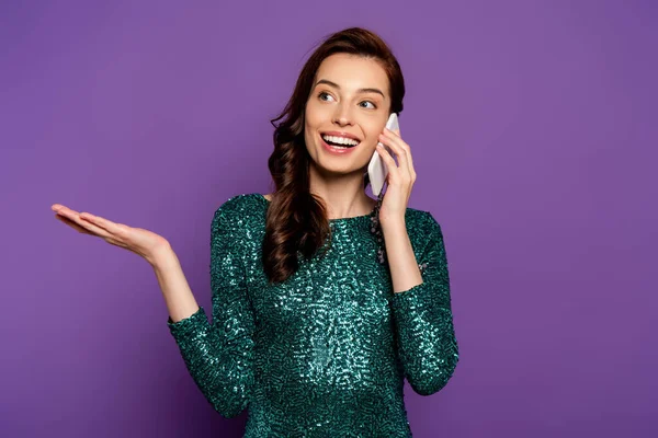 Mujer joven y feliz hablando en el teléfono inteligente y el gesto en púrpura - foto de stock