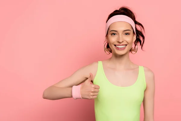 Happy young woman showing thumb up and smiling on pink — Stock Photo