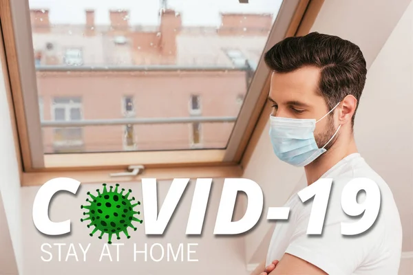 Side view of man in medical mask standing near window at home, covid-19 illustration — Stock Photo