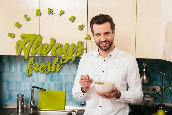 Bell'uomo che sorride alla telecamera mentre mangia cereali in cucina, colazione sempre illustrazione fresca — Foto stock