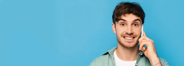 Encabezado del sitio web del hombre sonriente hablando en el teléfono inteligente aislado en azul — Stock Photo