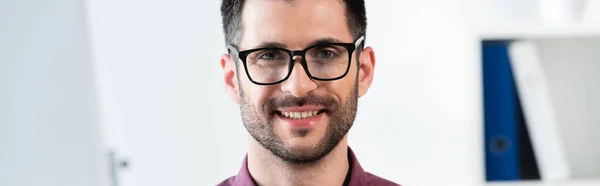 Retrato de joven, hombre de negocios guapo en gafas sonriendo a la cámara, concepto horizontal - foto de stock