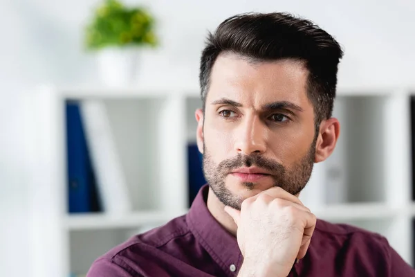 Beau, homme d'affaires réfléchi toucher le menton tout en détournant les yeux — Photo de stock