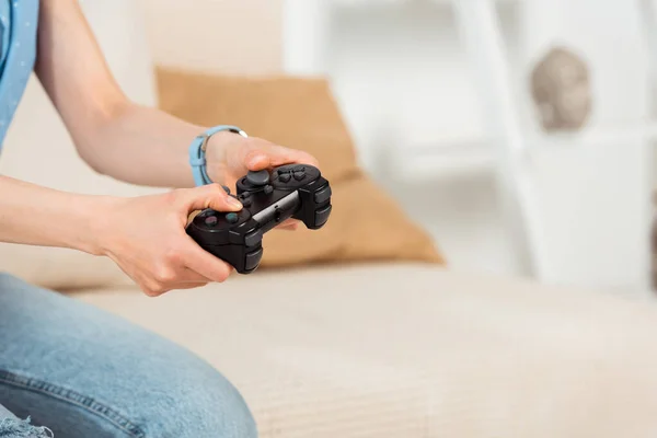 KYIV, UCRANIA - 4 de junio de 2020: Vista recortada de una mujer sosteniendo el joystick mientras juega un videojuego en casa - foto de stock