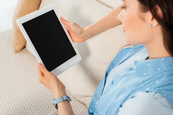Foco seletivo da jovem segurando tablet digital com tela em branco no sofá — Fotografia de Stock