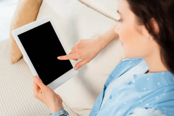 Foco seletivo de mulher jovem usando tablet digital com tela em branco no sofá — Fotografia de Stock