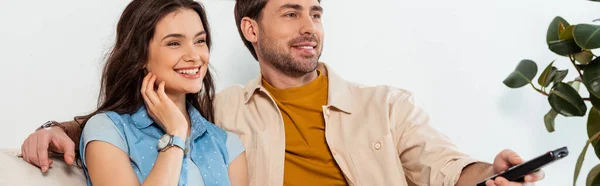 Panorâmica tiro de casal sorrindo assistindo filme em casa — Fotografia de Stock