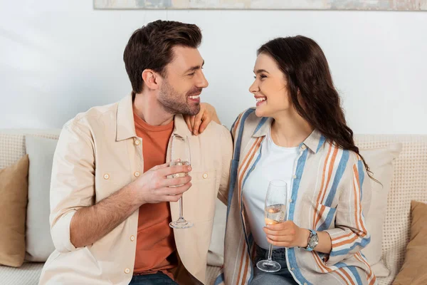 Donna felice che tiene un bicchiere di champagne e abbraccia il fidanzato a casa — Foto stock