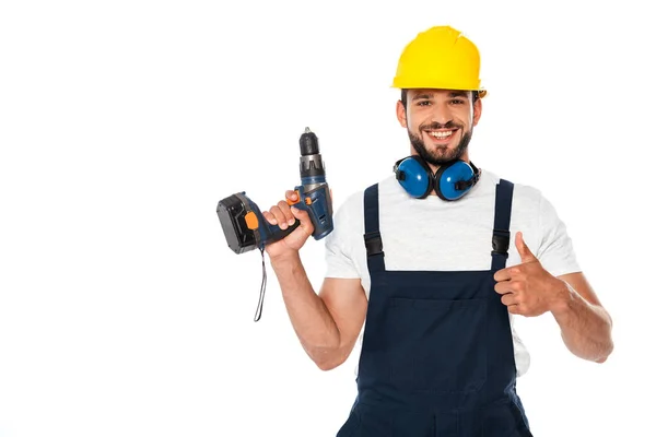 Sorrindo reparador mostrando como gesto e segurando chave de fenda elétrica isolada no branco — Fotografia de Stock