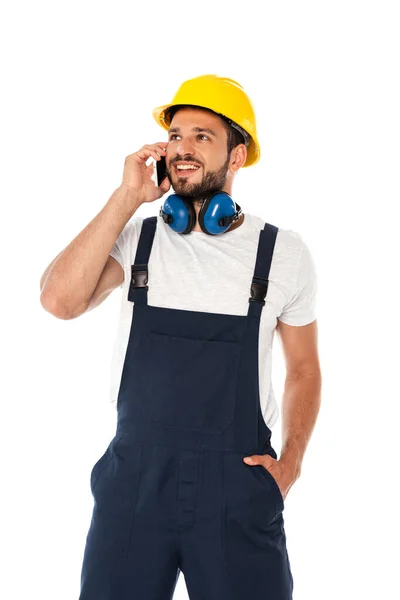 Reparador sonriente en overol hablando en smartphone aislado en blanco - foto de stock