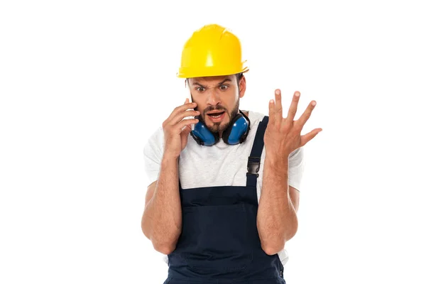 Obrero enojado haciendo gestos mientras habla en un teléfono inteligente aislado en blanco - foto de stock