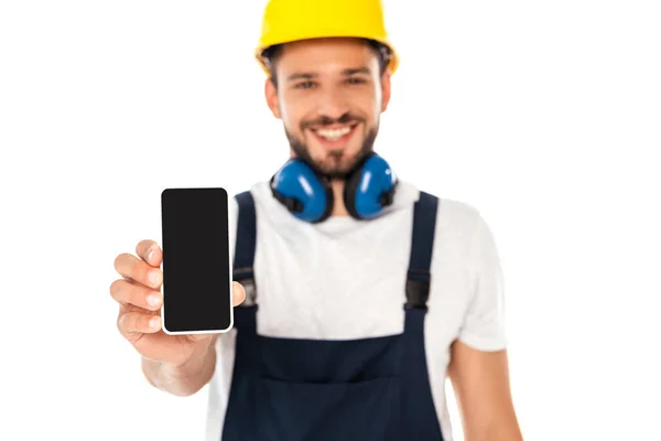 Selektiver Fokus eines lächelnden Arbeiters, der Smartphone mit leerem Bildschirm zeigt, isoliert auf Weiß — Stockfoto