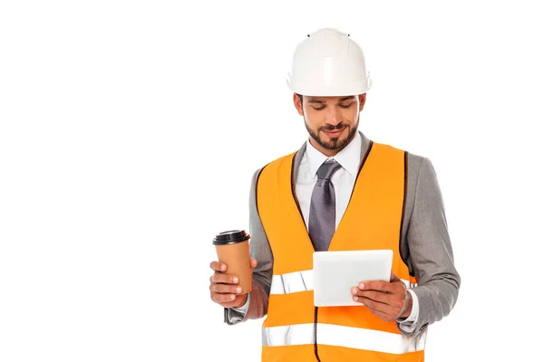 Ingeniero guapo en traje y hardhat sosteniendo café para llevar y tableta digital aislada en blanco — Stock Photo