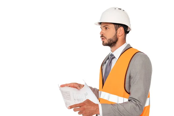 Ingeniero guapo en chaleco de seguridad y hardhat que sostiene el plano aislado en blanco - foto de stock