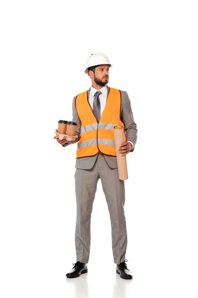 Ingeniero en traje y hardhat sosteniendo vasos de papel y tubo plano sobre fondo blanco - foto de stock