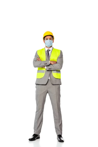Ingeniero en máscara médica con brazos cruzados mirando a la cámara sobre fondo blanco - foto de stock