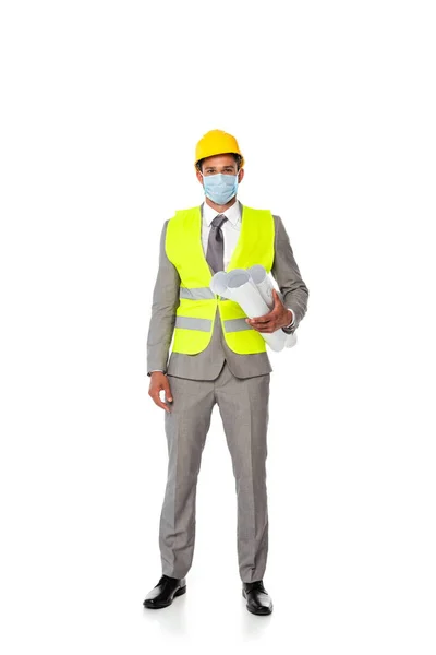 Инженер в костюме, защитный шлем и медицинская маска с чертежами на белом фоне — стоковое фото