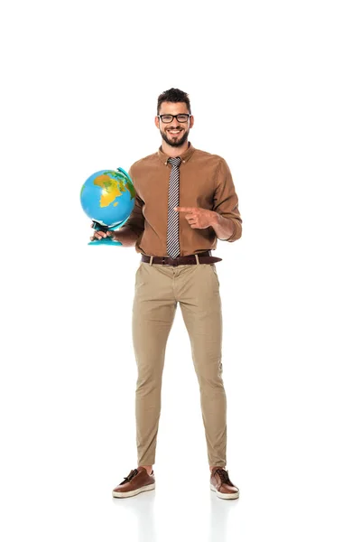 Professor bonito apontando com o dedo para o globo e sorrindo para a câmera no fundo branco — Fotografia de Stock