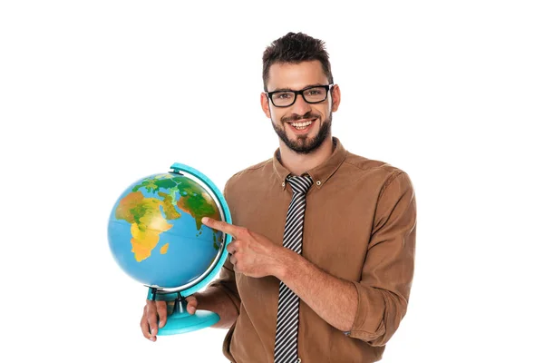 Bearded teacher smiling at camera while pointing with finger at globe isolated on white — Stock Photo