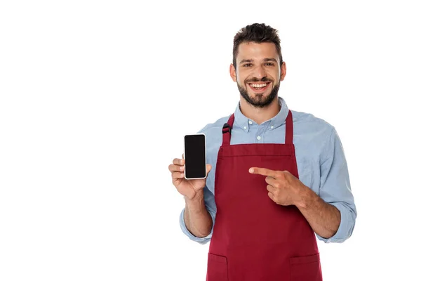 Camarero positivo apuntando con el dedo al smartphone con pantalla en blanco aislado en blanco - foto de stock