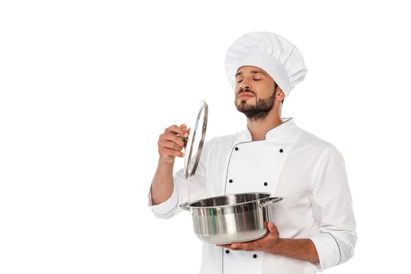 Chef bonito com olhos fechados segurando panela e tampa isolada em branco — Fotografia de Stock