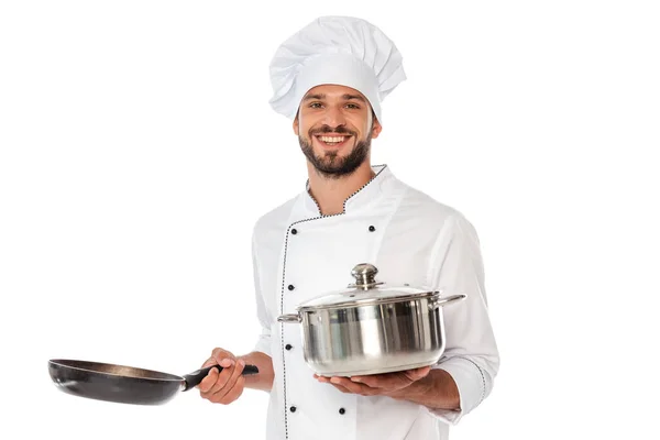 Chef sonriente en bandeja de sujeción uniforme y sartén aislada en blanco — Stock Photo
