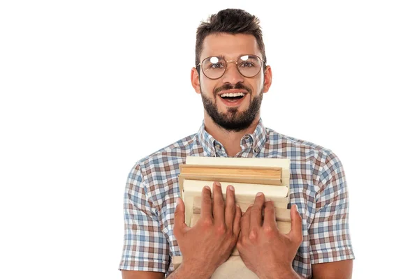 Nerd positivo in occhiali guardando la fotocamera mentre tiene libri isolati su bianco — Foto stock