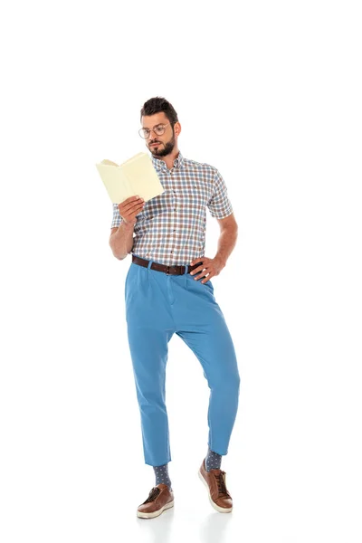 Nerd dans les lunettes avec la main sur la hanche livre de lecture sur fond blanc — Photo de stock