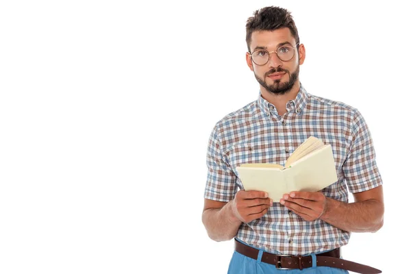 Guapo nerd en gafas con libro abierto y mirando a la cámara aislada en blanco - foto de stock