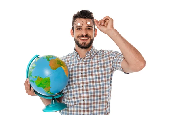 Sorridente nerd che tiene gli occhiali e globo mentre guarda la fotocamera isolata su bianco — Foto stock