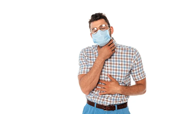 Nerd en máscara médica tocando cuello y vientre aislado en blanco - foto de stock